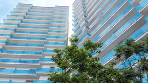 Un edificio moderno e di alta quota, caratterizzato da numerosi balconi e un cielo sereno sullo sfondo.