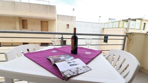 A balcony table with a bottle of wine, two glasses, and a magazine. - Wonderful  villa for 4 guests with A/C, WIFI, TV and balcony (Otranto)
