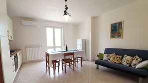 A living area with a dining table, chairs, a sofa, and a radiator. - Wonderful  villa for 4 guests with A/C, WIFI, TV and balcony (Otranto)