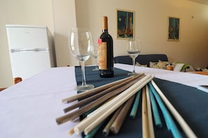A table with a bottle of wine, two glasses, and a set of chopsticks. - Stunning  villa for 4 guests with WIFI, A/C, TV and balcony (Otranto)