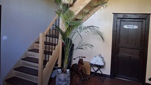 A wooden staircase with a potted plant, a horse statue, and a door labeled 'PRIVE.' - Bed and Breakfast 'La Chambre Des Cerfs' with Shared Pool, Private Terrace and Wi-Fi (Moissannes)