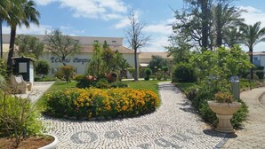 A courtyard with a cobblestone path, a flower bed, and a building labeled 'Oasis Park.'