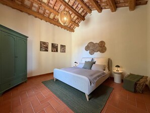A bedroom with a bed, a green wardrobe, a wooden ceiling, and a wall with three framed pictures. - Villa di Pietro – Historic/newly renovated stone villa with a pool and ocean view! (Sicilia)