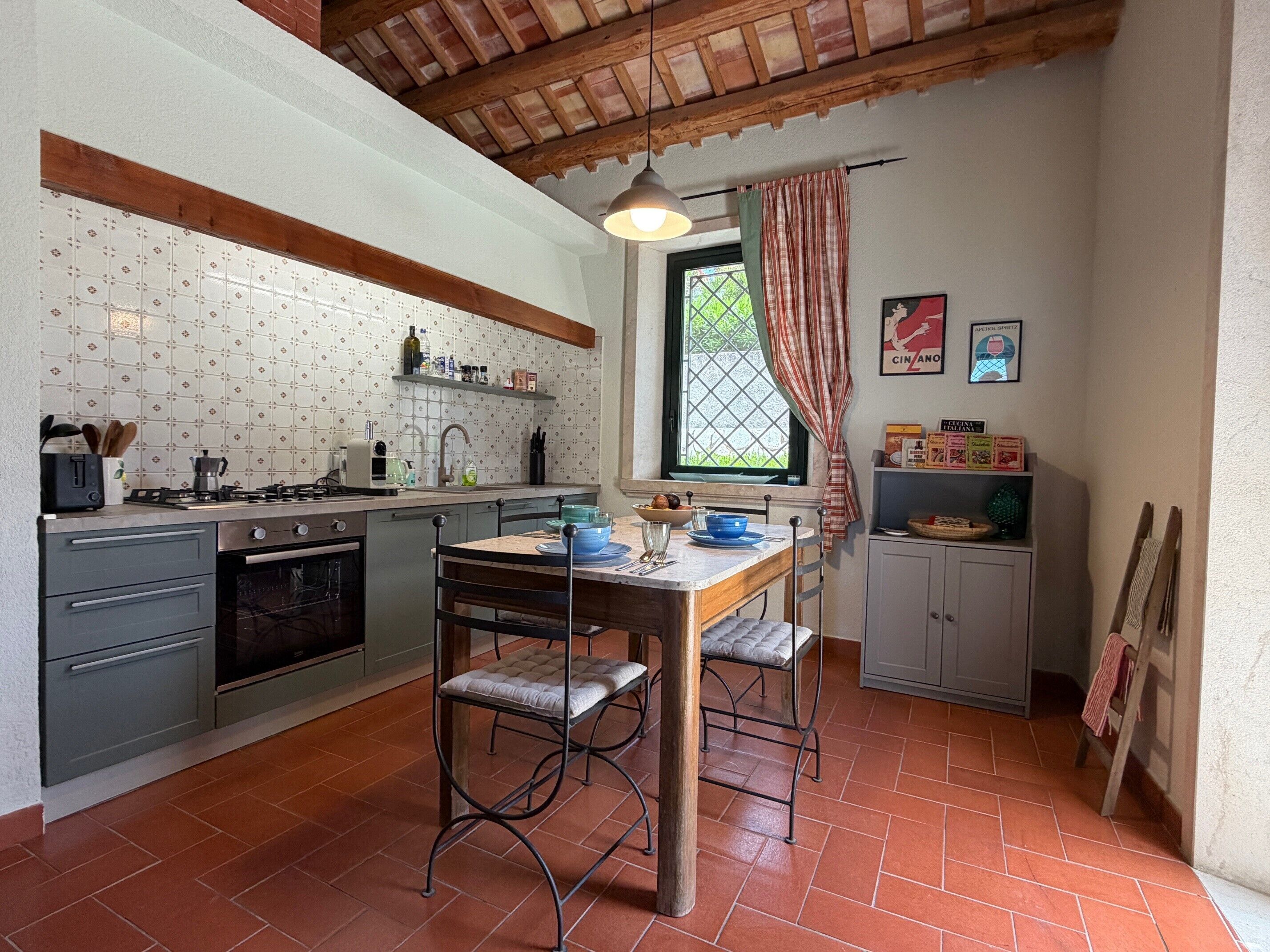 A compact kitchen with a gas stove, oven, and a dining area with a table and chairs.