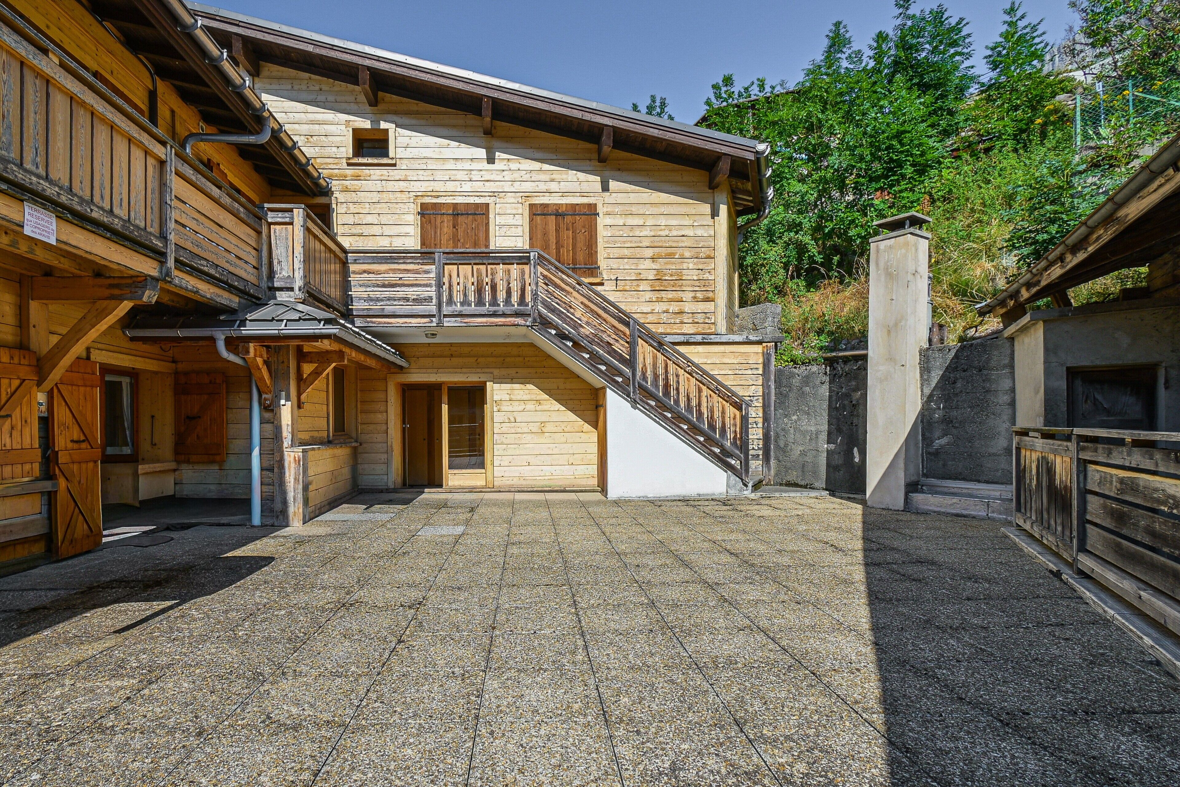 Un bâtiment en bois avec un escalier menant à un balcon.