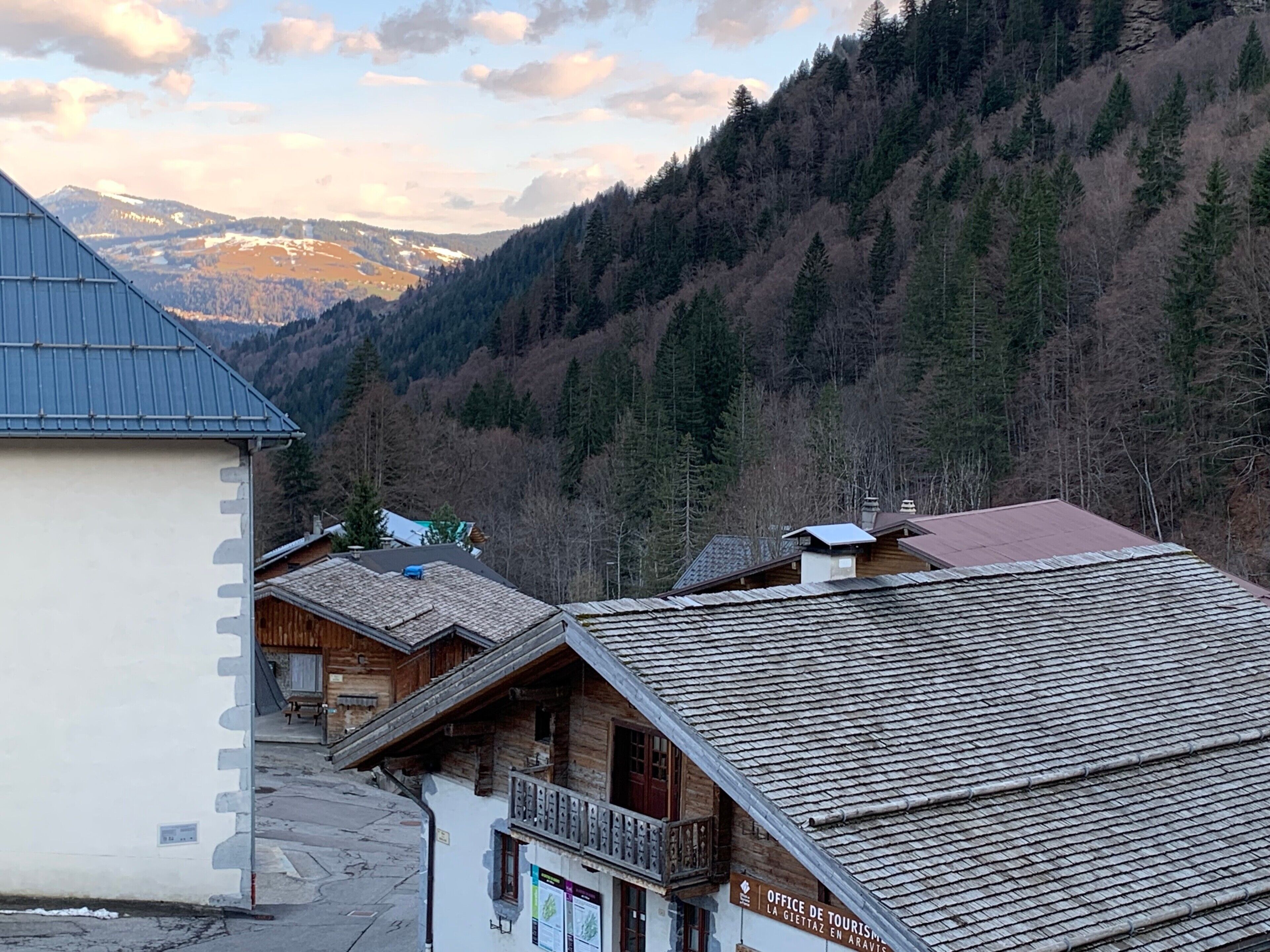 Un pueblo de montaña con edificios de madera y vistas a montañas nevadas.