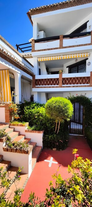Un edificio de varios pisos con un patio, escaleras y una puerta.