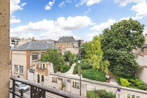 A view of a street with buildings, a tree, and a sign reading 'SQUARE DES VICTIMES DE LA GESTAPO'. - Le Jeanne d’Arc – City center & sleeps 8 (Reims)
