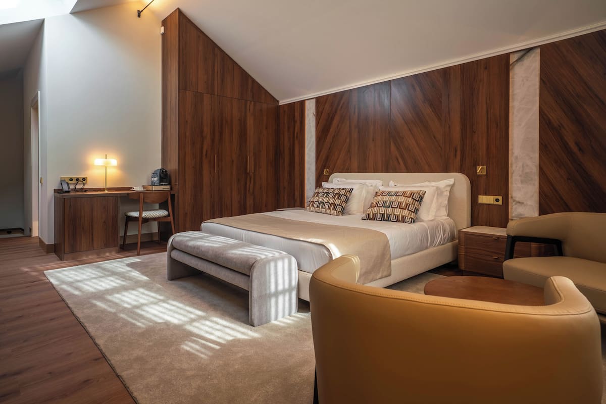 Une chambre à coucher avec un lit, des tables de chevet, un bureau et une chaise.