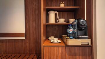 Un mueble de madera con cafetera, tazas y dispensador de agua.