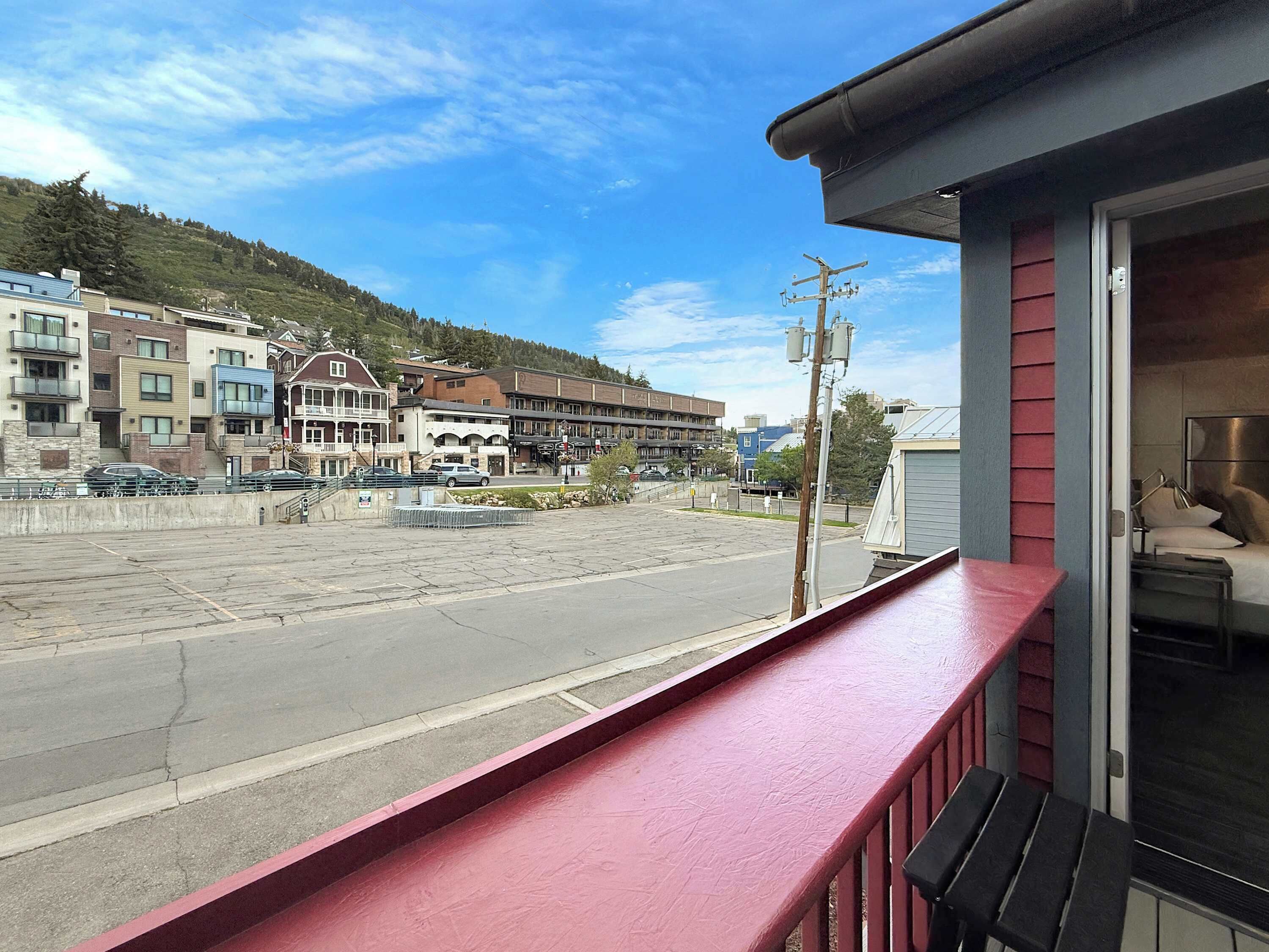 A hotel balcony with a view of a street and buildings.