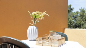 A table with a white vase, a wicker tray, and a glass jar. - Studio Aura by Propertize - centro Olbia (Olbia)