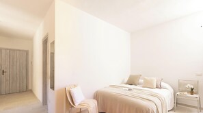 Ein Schlafzimmer mit Bett, Stuhl, Nachttisch und Spiegel.