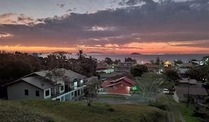 A residential area with houses, a body of water, and a distant island. - Fully furnished apartment near the beach and Beto Carrero World! (Penha  SC)