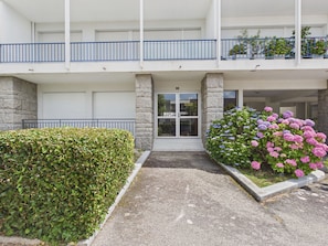 A two-story building with a flat facade, a gated entrance, and a small garden with hydrangea flowers. - 100 m from the sea – Apartment for 4 with terrace (Bénodet)