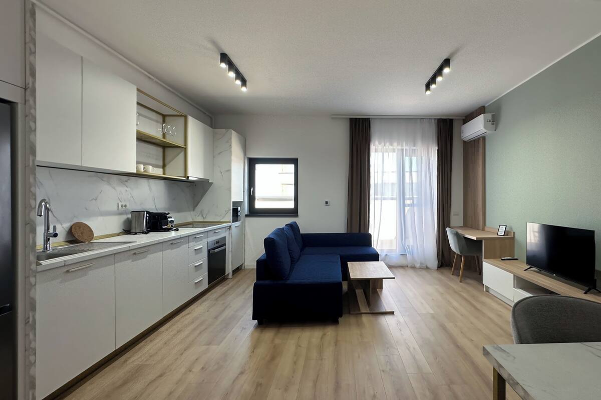 A modern apartment with a kitchen, living area, and a TV.