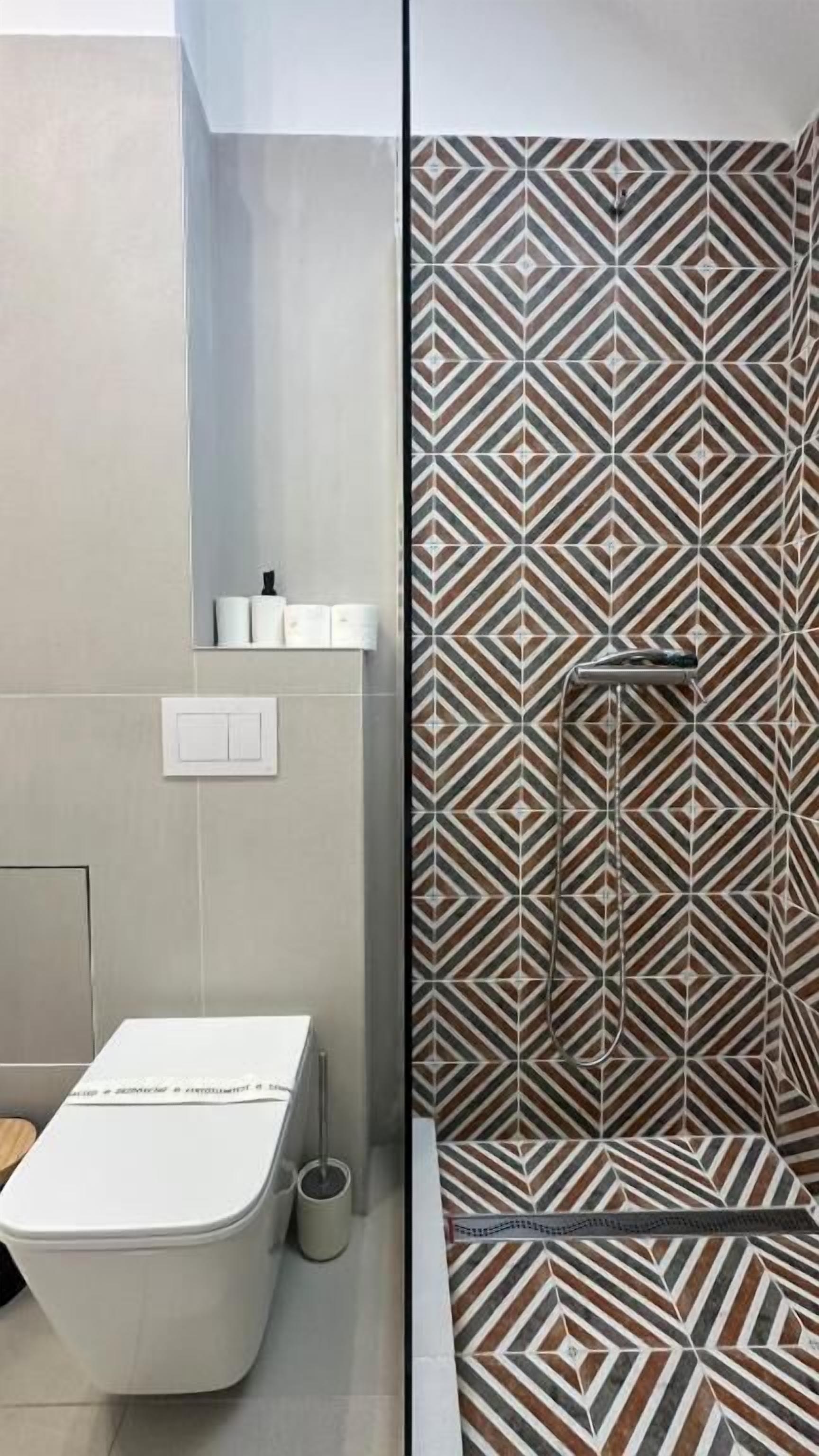 A bathroom with a toilet, sink, and shower area.