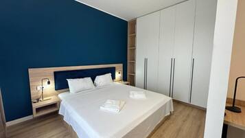 A bedroom with a bed, bedside tables, a wardrobe, and a nightstand.