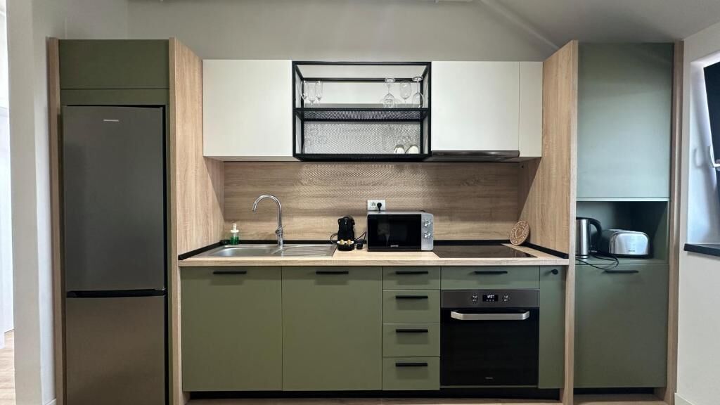 Een moderne keuken met een ingebouwde magnetron, een spoelbak en een vaatwasser.
