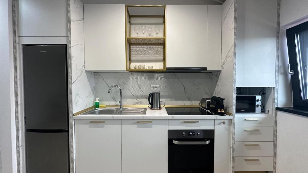 Una cocina compacta con refrigerador, estufa, microondas y lavavajillas.