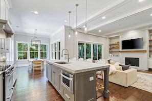 A modern kitchen with a central island, stainless steel appliances, and large windows. - Sunset Rentals | 38 Governors Lane (Hilton Head Island)