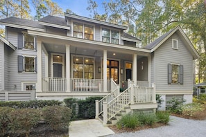 A two-story house with a covered porch, a front staircase, and a well-maintained garden. - Sunset Rentals | 38 Governors Lane (Hilton Head Island)