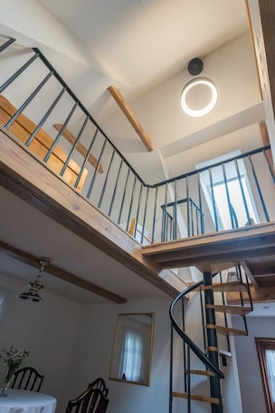 A multi-level interior with a spiral staircase, wooden beams, and a ceiling light fixture.. Historic 70m2 Farmhouse - 3 Rooms, Terrace - by Rentujemy