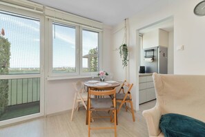 Ein Essbereich mit Tisch, Stühlen und Blick durch große Fenster.