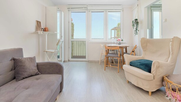 A living room with a sofa, armchair, and a small table with chairs. - Sunny Studio with a Balcony | Gdańsk | Close to Nature (Gdańsk)