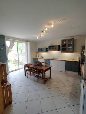 Una cocina moderna con comedor, ventanas amplias y vistas al exterior.