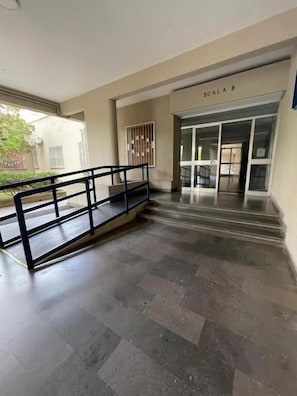 A hallway with a black metal railing, a tiled floor, and a door labeled 'SCALA B'. - Panta Rei Camere di Charme e Spa (Taranto)