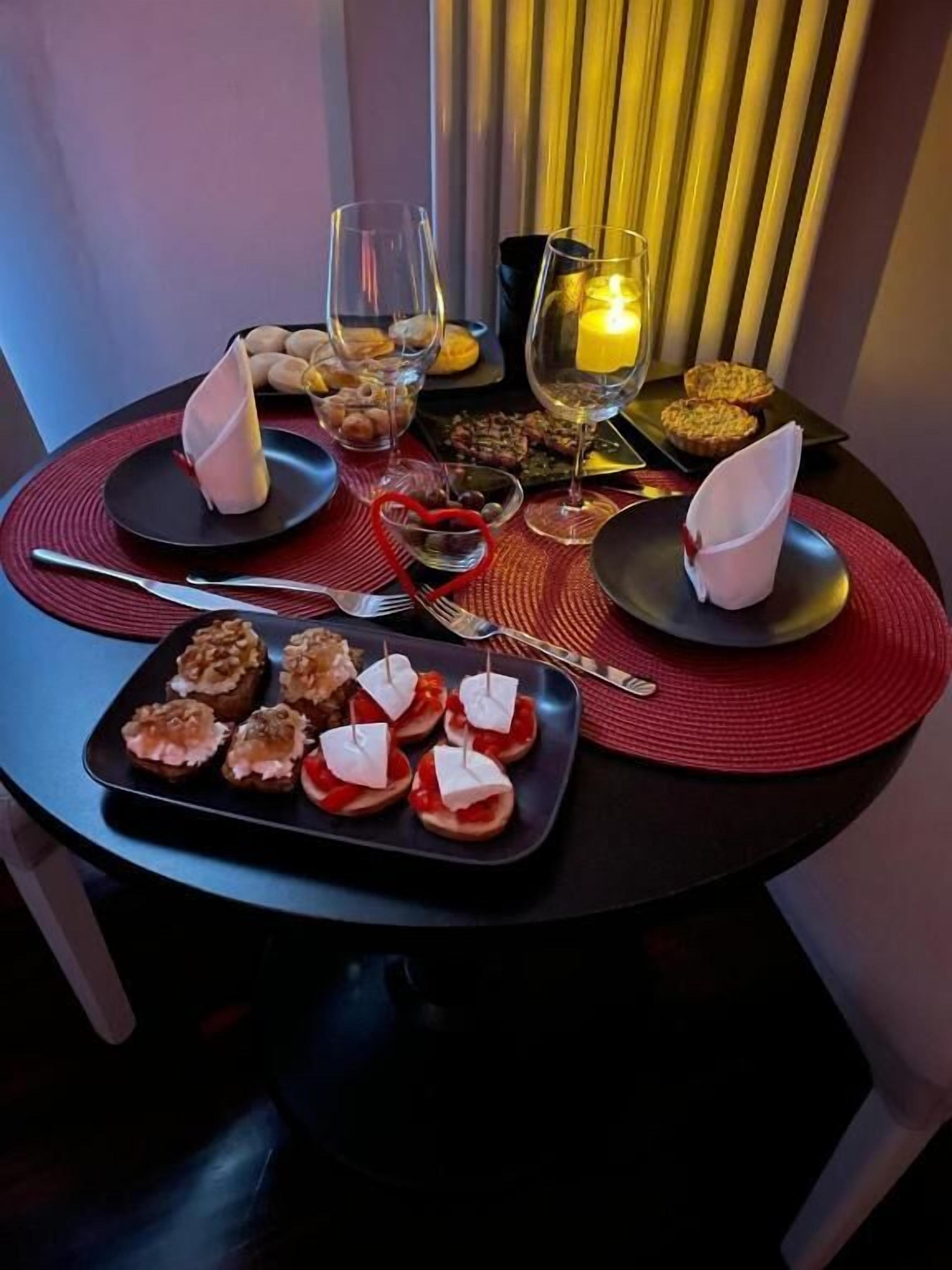 A dining table set with plates, glasses, and a candle.