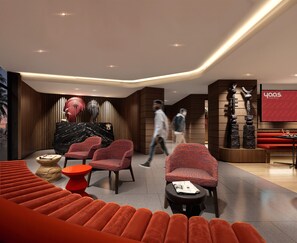 A modern hotel lobby with seating areas, a reception desk, and a wall-mounted sculpture.