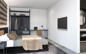 Un dormitorio moderno con cama, escritorio y silla. Hay un armario con ropa colgada y un televisor de pantalla plana montado en la pared.