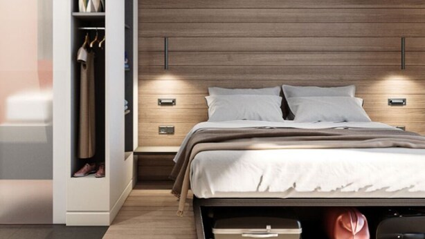 A modern bedroom with a wooden headboard, a built-in wardrobe, bedside tables, and a bed with a white comforter.