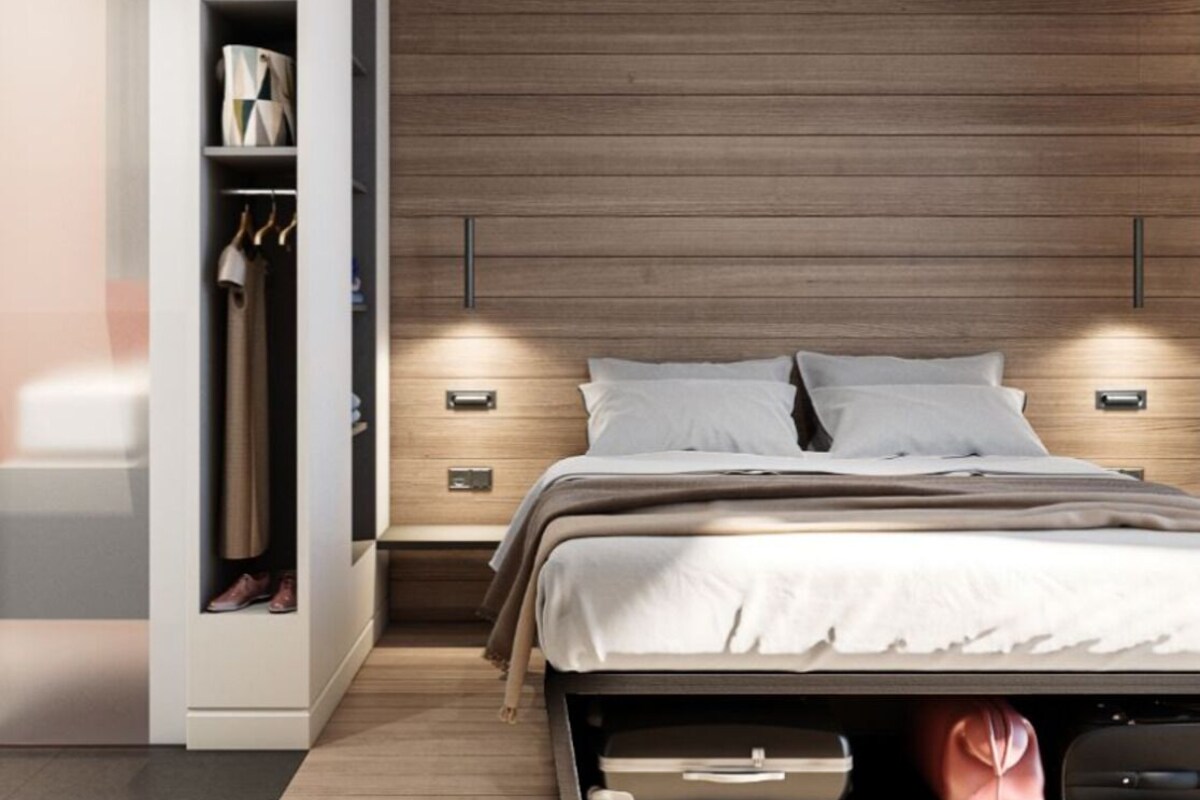 Un dormitorio moderno con cabecera de madera, armario empotrado, mesitas de noche y cama con edredón blanco.
