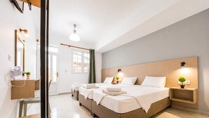 A hotel room with a large bed, bedside tables, a mirror, and a ceiling light. - Nikos Villas - Garden & Pool View Gem in Kavos (Kavos)