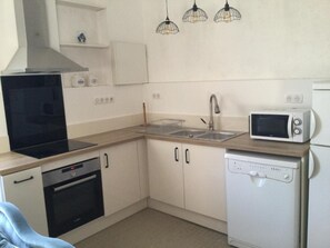 Cuina compacta amb fornet, vitroceràmica, microones, rentapelats i rentavaixelles.