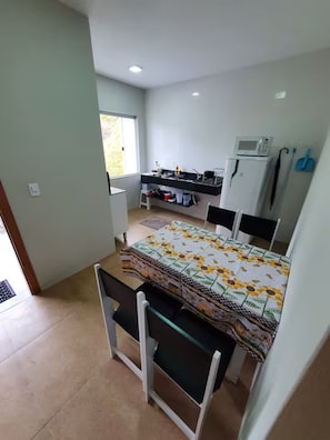 Ein kleines, gemütliches Zimmer mit Bett, Küchenzeile und Fenster.