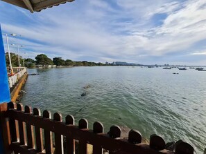 Une vue sur le front de mer, avec une balustrade en bois, une eau calme et des bateaux.