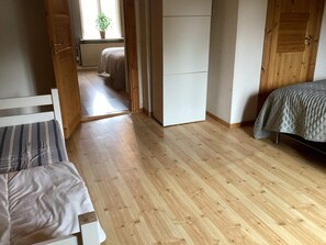A room with a bed, a desk, and a wardrobe. There is a window with a plant on the sill. - 4 Star Holiday Home in Knared (Knared)