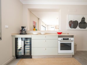 A modern kitchen with a built-in dishwasher, a coffee maker, and a microwave. - Rivara Rooftop Apartamento T3 de luxo (Cabanas de Tavira)