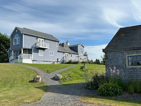 A two-story house with a front porch, a driveway, and a small garden area.