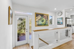 Eine moderne Küche mit weißen Schränken, einer Holz Arbeitsplatte und einem großen Fenster.