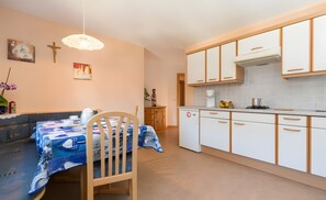 Eine gemütliche Küche mit Esstisch, Stühlen und einem kleinen Kühlschrank.