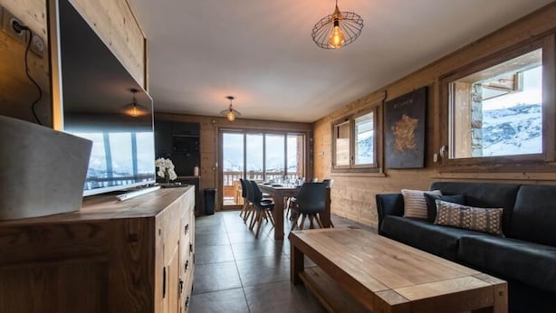 Ein modernes Interieur mit einer Holzessecke, einer Couch und einem großen Fenster mit Blick.