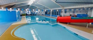 An indoor swimming pool with a blue and white color scheme, a diving board, and a red slide. - Cabin Sleeps 6 With Garden and Pets Welcome (Cowes)