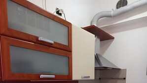 Una cocina con un lavaplatos de acero inoxidable, un microondas, una estufa a gas y armarios de madera.