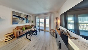 Un salon moderne avec un canapé, une table basse et une vue sur l’extérieur.