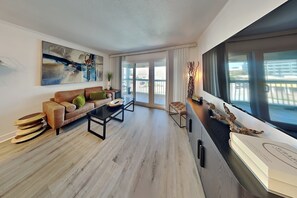 Ein modernes Wohnzimmer mit Sofa, Couchtisch und Blick ins Freie.